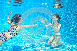 Children swim in pool underwater, happy active girls have fun under water