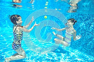 Children swim in pool underwater, happy active girls have fun under water