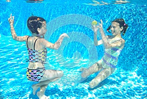 Children swim in pool underwater, happy active girls have fun under water