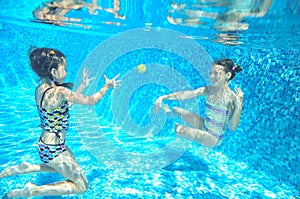 Children swim in pool underwater, happy active girls have fun under water, kids sport