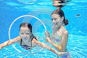 Children swim in pool underwater, happy active girls have fun under water