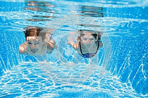 Children swim in pool underwater, happy active girls have fun in water, kids fitness and sport on family vacation