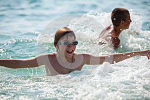 Children swim in the sea during summer holidays