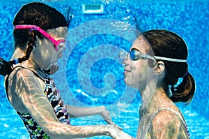 Children swim in swimming pool underwater, happy active girls have fun under water, kids fitness and sport