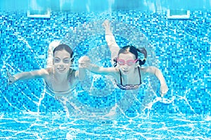 Children swim in swimming pool underwater, happy active girls have fun under water, kids fitness and sport