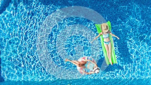 Children in swimming pool aerial drone view from above, happy kids swim on inflatable ring donut and mattress