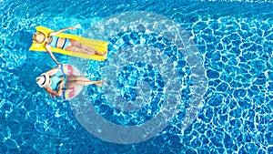 Children in swimming pool aerial drone view fom above, happy kids swim on inflatable ring donut and mattress, girls have fun