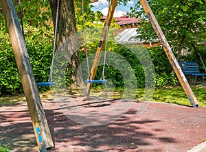 Children swings in a park with trees