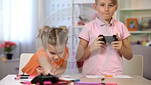 Children taking consoles to play video game instead of drawing, technology