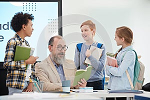 Children Talking to Teacher in School