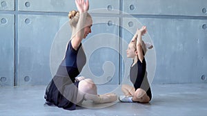 Children and teacher at the ballet school. Beautiful ballerinas in black tutus at a ballet lesson. Lovely girls dance at