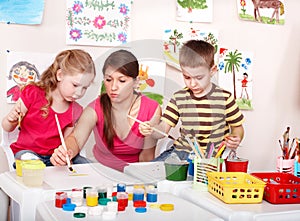 Children with teacher painting play room.