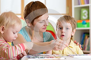 Children with teacher painting in playschool photo