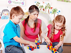 Children and teacher with wood block in preschool.