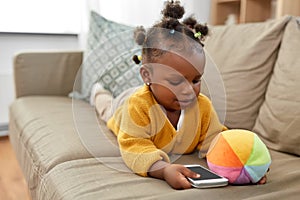 African american baby girl with smartphone at home