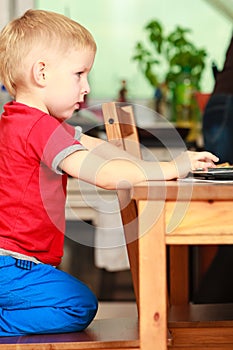 Little boy using laptop computer playing games