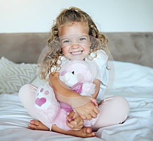 Children, teddy bear and girl child hug her stuffed animal with a smile in her house. Portrait of kid, happy and safe