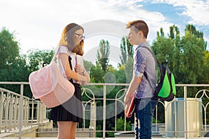 Children teenagers with backpacks, textbooks, notebooks go to school, back to school.