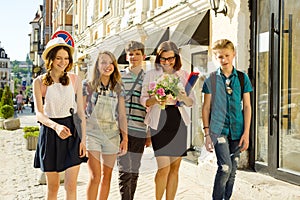 Children teenagers go with their teacher. The students congratulated female with bouquet of flowers. Teacher`s Day