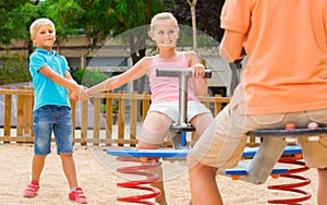 children are teetering on the swing in the playground. photo