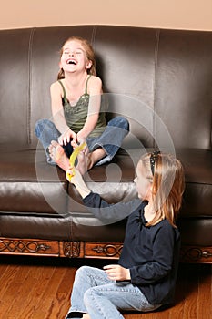 Children tickling feet with feather
