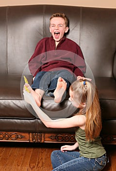 Children tickling feet with feather