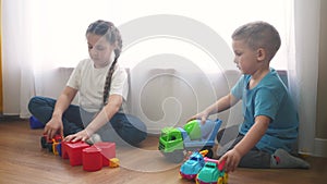 Children toddler a playing toy car on the floor. Happy family kindergarten kid dream concept. Children toddler play toys