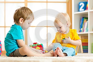 Children toddler preschooler boys playing logical toy learning shapes and colors at home or nursery