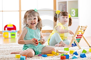 Un nino a nino en edad preescolar las chicas jugar lógico juguete el estudio formas aritmética a colores en jardín de infancia o 