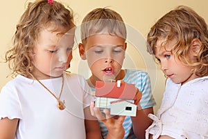 Children together keeping in hands model of house