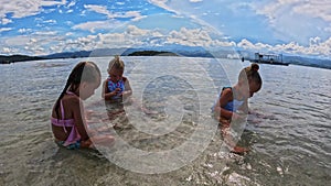 Children of the Triplet Sister play on the beach and in shallow water