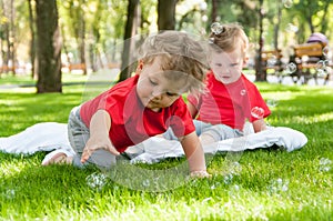 Children twins play on the grass