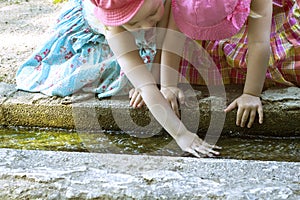 Children. Two girls playing with water in a creek on a hot sunny day