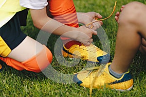 Children tying shoe laces. Kids on sports football team tying soccer cleats