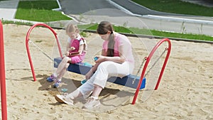 Children use a computer tablet, walk on the playground
