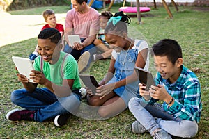 Children using tablet computer with man at park