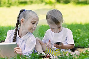 Children using tablet PC and smartphone in perk