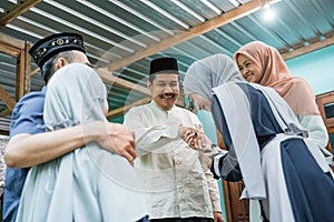 children visiting their parent and shake hand on idul fitri