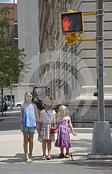 Children wait to cross street at stop signal