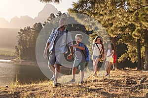 Children Walk By Lake With Parents On Family Hiking Adventure photo