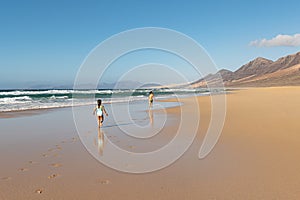 Children walking on Cofete beach, Fuerteventura island