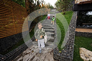 Children walking on stairs against modern wood stone house