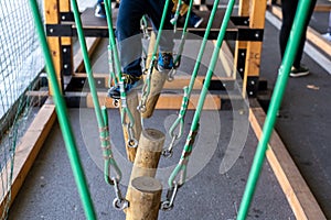 Children walking on trunks suspended by ropes in an adventure park