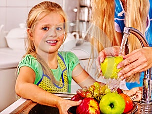 Children washing fruit at kitchen photo