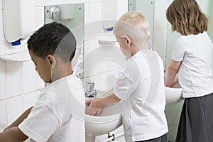 Children washing their hands in a school bathroom