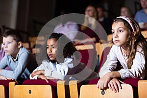 Children watch with interest performance in theater or concert