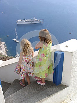 Children watching boats at Oia, Santorini, Greece