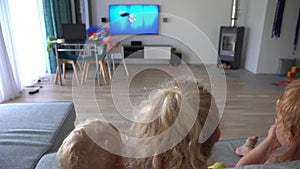 Children watching movie on big tv home cinema in living room. camera movement