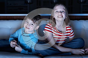 Children Watching TV Together Sitting On Sofa
