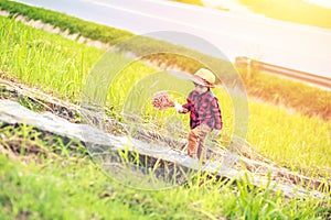 A children wear hat and walking on stair. A children hold flower and near the road.